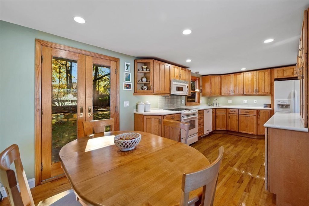 7 Irving Road Natick, MA 01760 - Photo 11 of 39 a kitchen with stainless steel appliances granite countertop a stove top oven a sink dishwasher a dining table and chairs with wooden floor