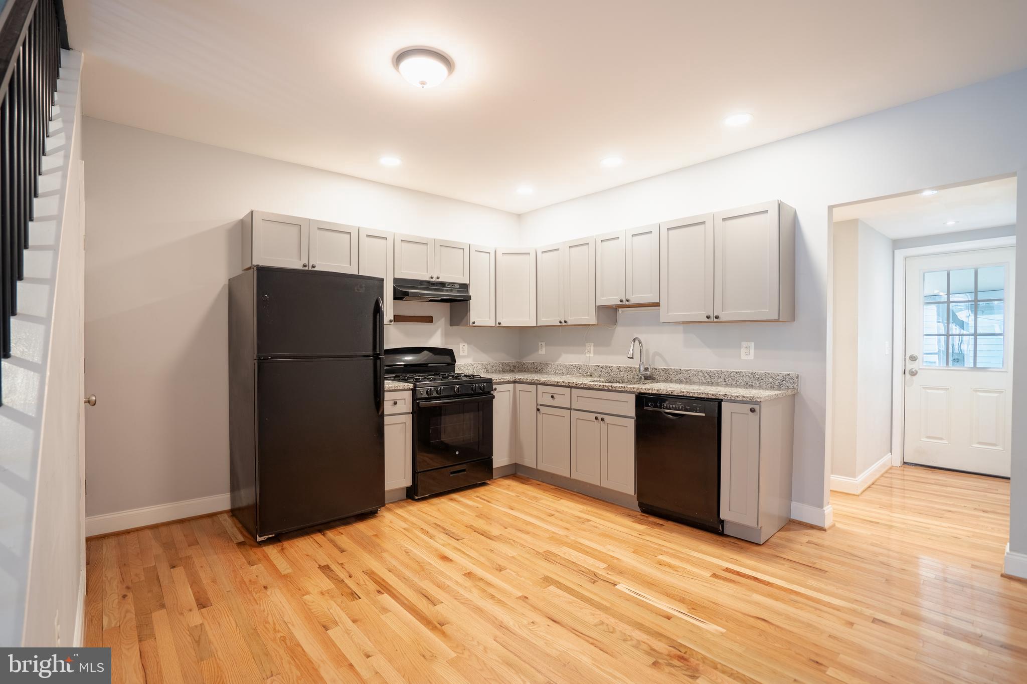 3804 Falls Road Baltimore, MD 21211 - Photo 5 of 18 a kitchen with granite countertop a refrigerator and a stove top oven