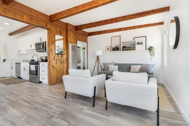 a kitchen with white cabinets stainless steel appliances and wooden floor