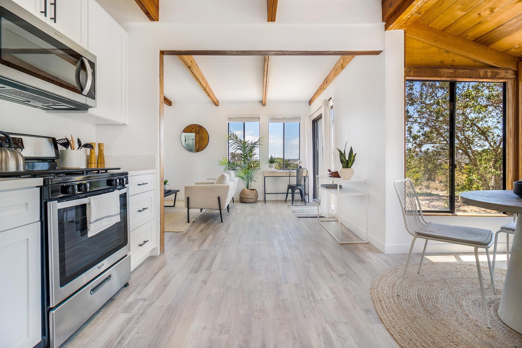 3854 Via Del Mar San Diego, CA 92130 - Photo 3 of 61 a kitchen with stainless steel appliances a stove a table and chairs with wooden floor