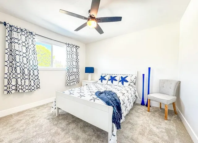 a bedroom with a bed a chair and potted plant on the table