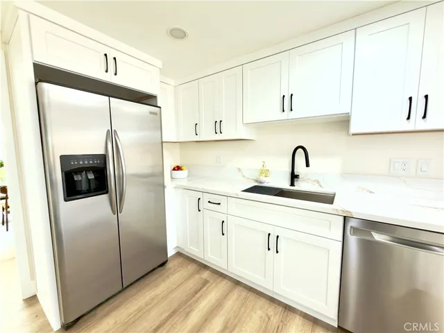 a kitchen with a refrigerator sink and cabinets