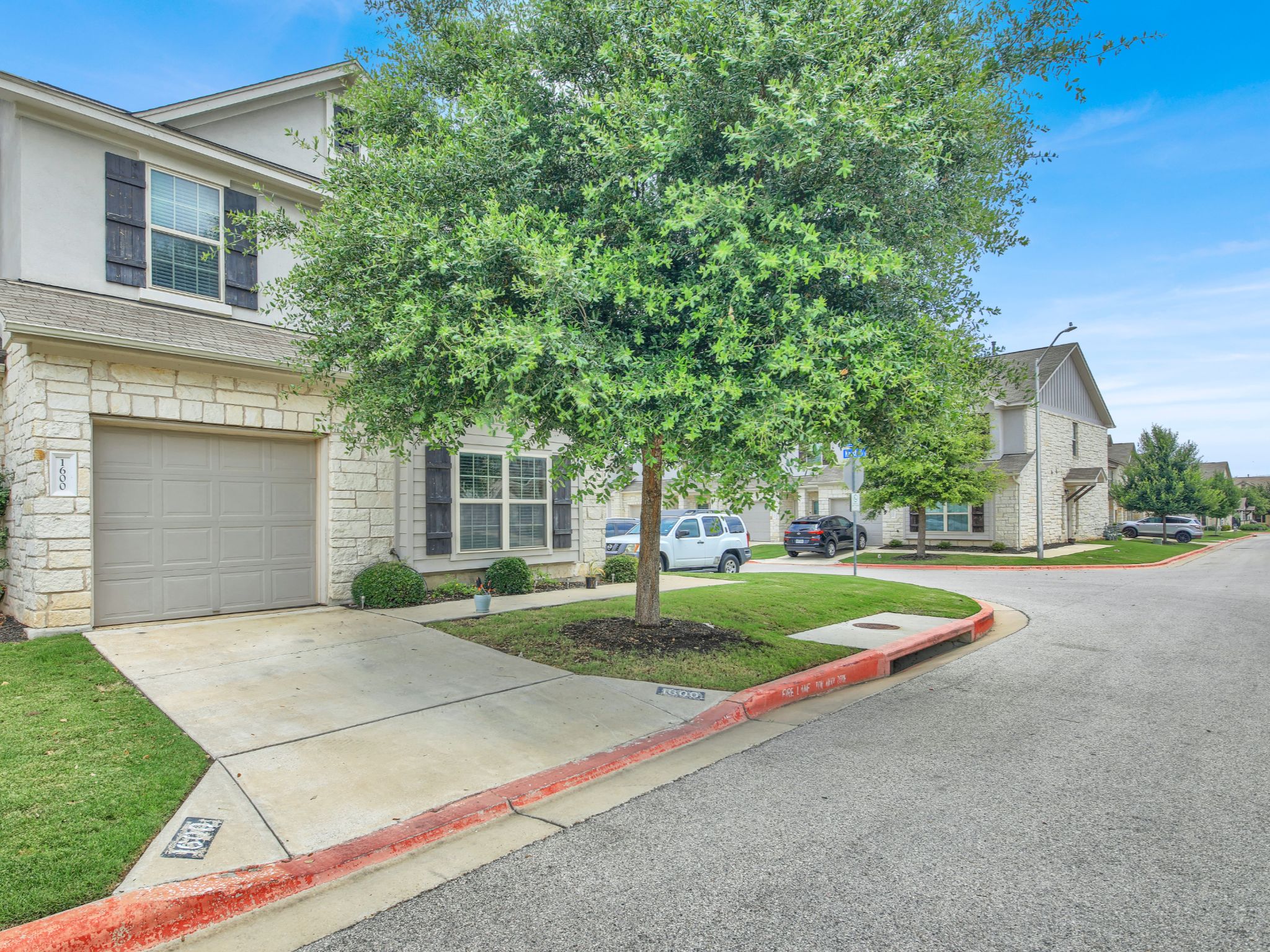 1600 Airedale Road, Unit 2601 Austin, TX 78748 - Photo 2 of 26 A welcoming stone and stucco facade with shuttered windows, set amongst a neatly kept lawn and mature trees.