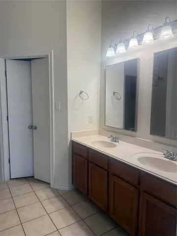 a bathroom with a double vanity sink and a mirror