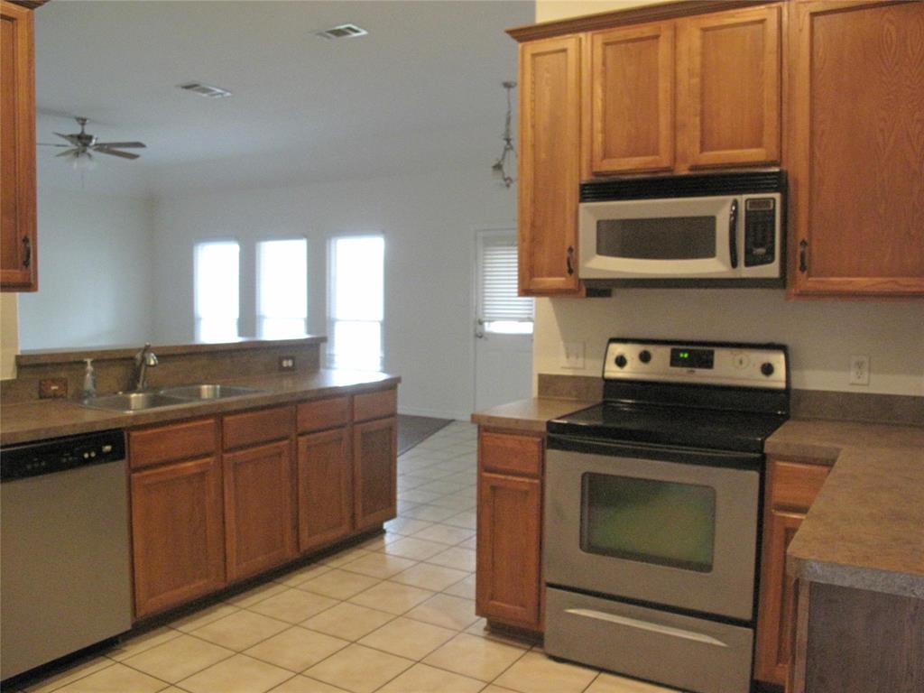 303 Quail Run Road Red Oak, TX 75154 - Photo 6 of 19 a kitchen with stainless steel appliances granite countertop a stove microwave and cabinets