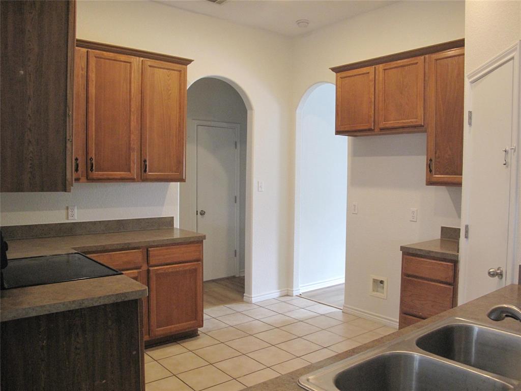 303 Quail Run Road Red Oak, TX 75154 - Photo 8 of 19 a kitchen with stainless steel appliances granite countertop a sink and a refrigerator
