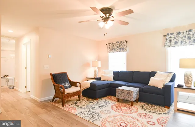 a kitchen with stainless steel appliances kitchen island granite countertop a refrigerator a stove a microwave oven a dining table and chairs with wooden floor