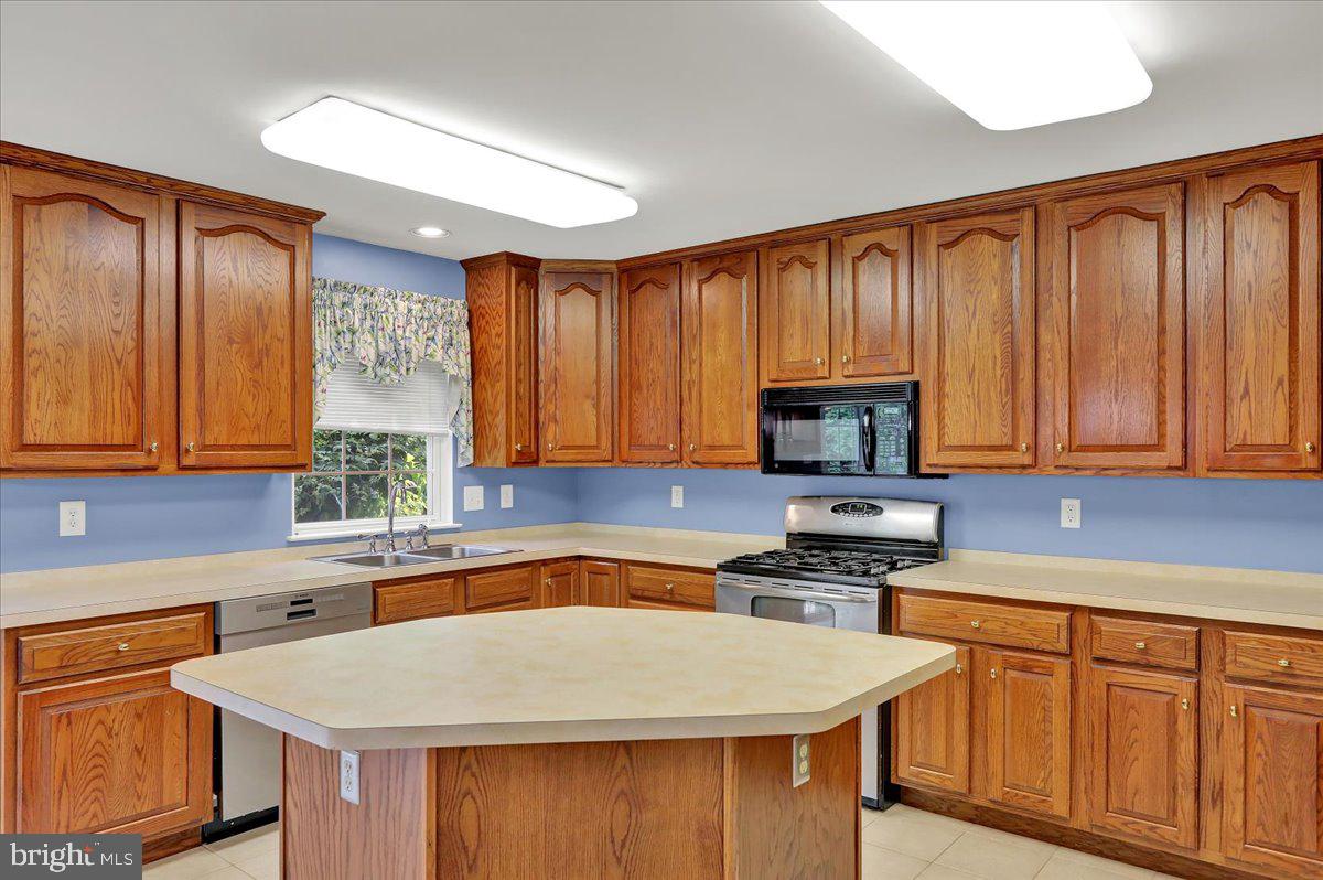 203 Barrington Drive Reading, PA 19607 - Photo 10 of 44 a kitchen with wooden cabinets a stove top oven a sink and dishwasher