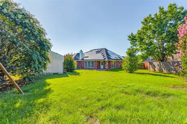 a view of a house with backyard and tree
