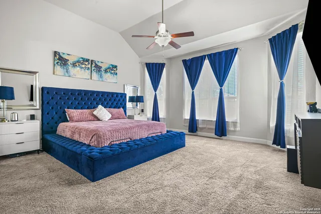 a spacious bedroom with a large bed and a chandelier