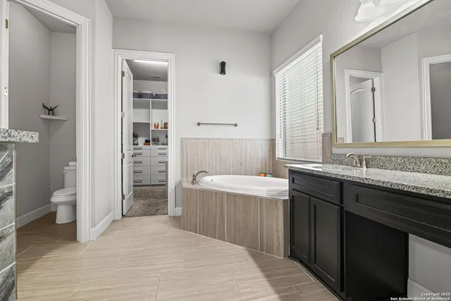 a bathroom with a granite countertop sink a toilet and shower