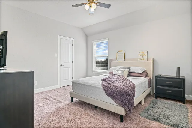 a bedroom with a bed and a ceiling fan