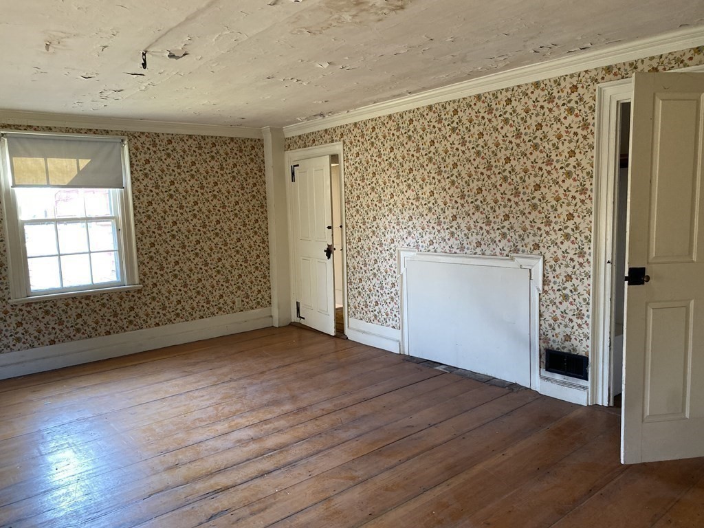 85 Main Street Groveland, MA 01834 - Photo 17 of 18 an empty room with wooden floor and a fireplace