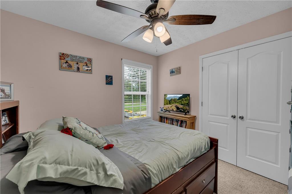 587-j B J B Owens Road Bethlehem, GA 30620 - Photo 48 of 99 a bedroom with a large bed and a chandelier