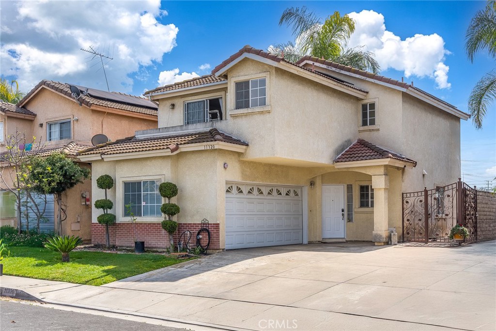 11320 Iris Lane El Monte, CA 91731 - Photo 1 of 14 a front view of a house with a yard and garage