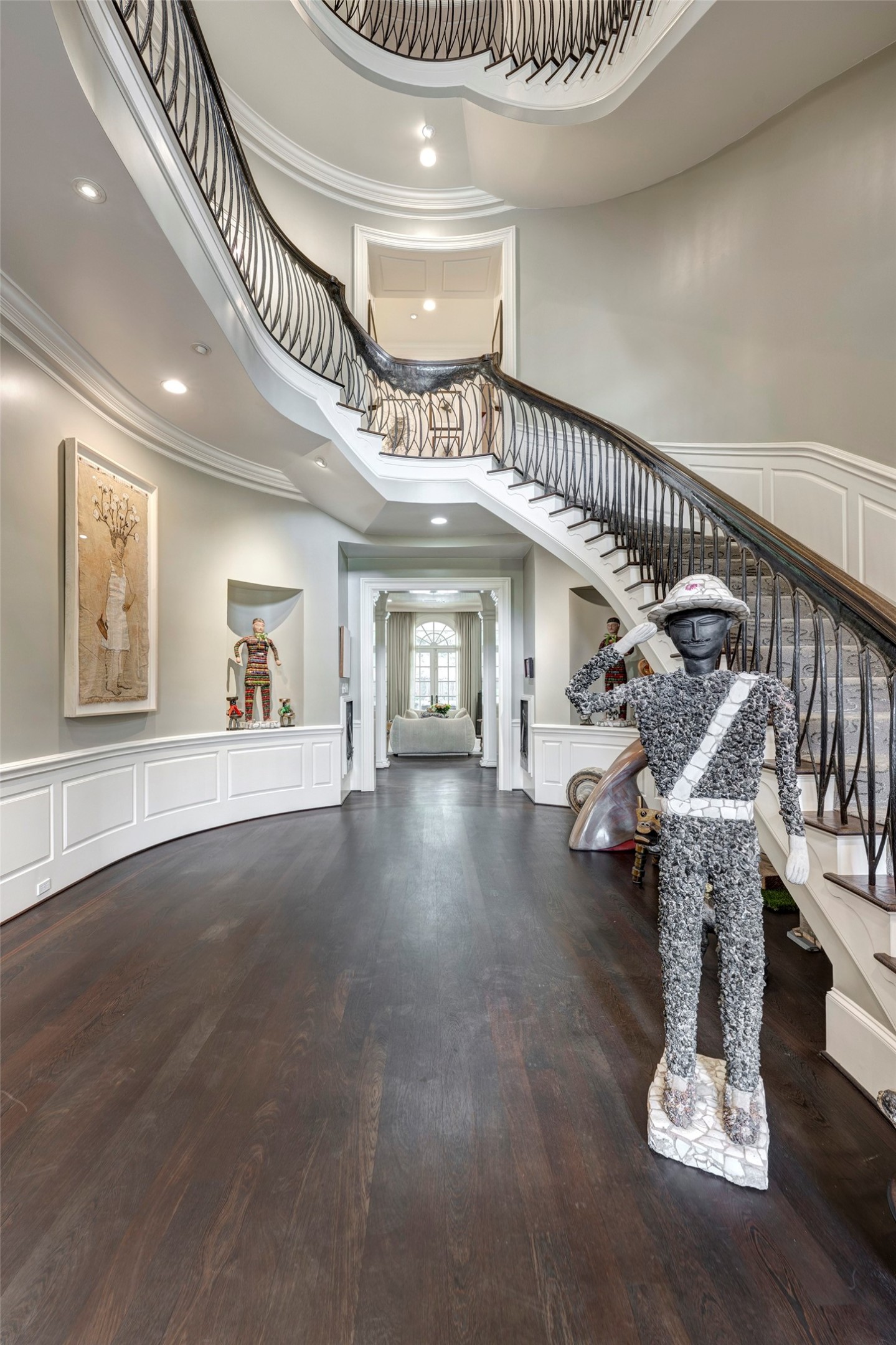 3653 Inverness Drive Houston, TX 77019 - Photo 3 of 39 Step into the stunning foyer and be captivated by the exquisite Ed Wilson custom-designed wrought iron railing, elegantly topped with a rich oak cap. The magnificent staircase not only draws the eye but also offers breathtaking tiered views leading up to the third floor, creating an unforgettable first impression.