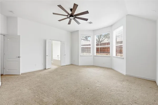 a view of a big room with windows and chandelier fan