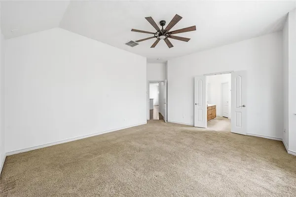 an empty room with ceiling fan and window