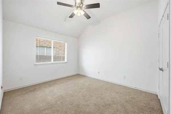 an empty room with a window and a fan