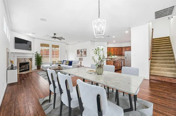 a view of a dining room with furniture a fireplace and wooden floor