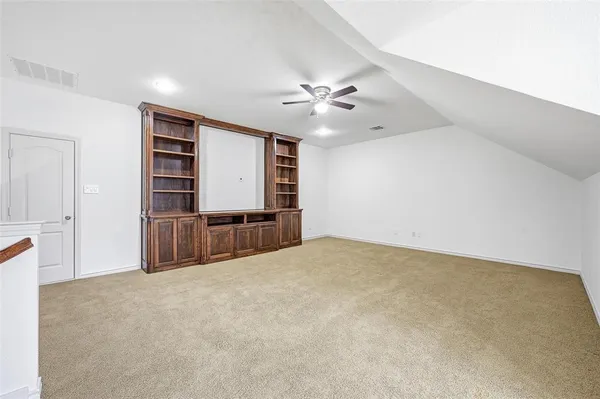 a view of an empty room with a ceiling fan