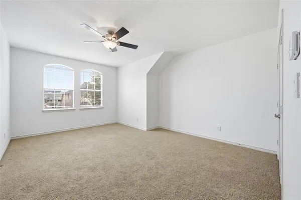 an empty room with windows and fan