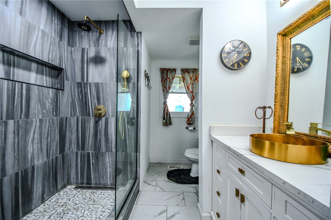 6169 Dayton Farmersville Road Dayton, OH 45417 - Photo 42 of 64 This bathroom features a contemporary shower and a vanity with a unique golden sink.