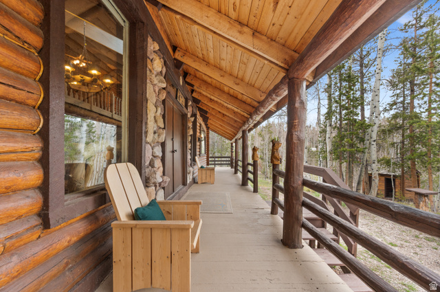 4725 Pine Ridge Road Evanston, UT 82930 - Photo 53 of 82 Expansive wood-finish porch featuring a log construction exterior with stone accents