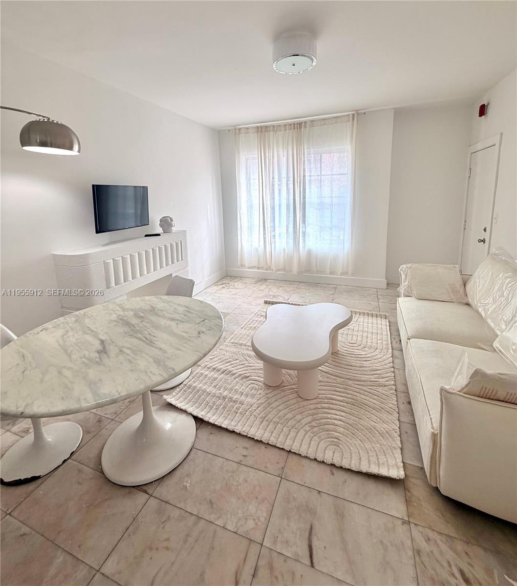 801 8th Street, Unit 202 Miami Beach, FL 33139 - Photo 2 of 9 a living room with furniture and a flat screen tv