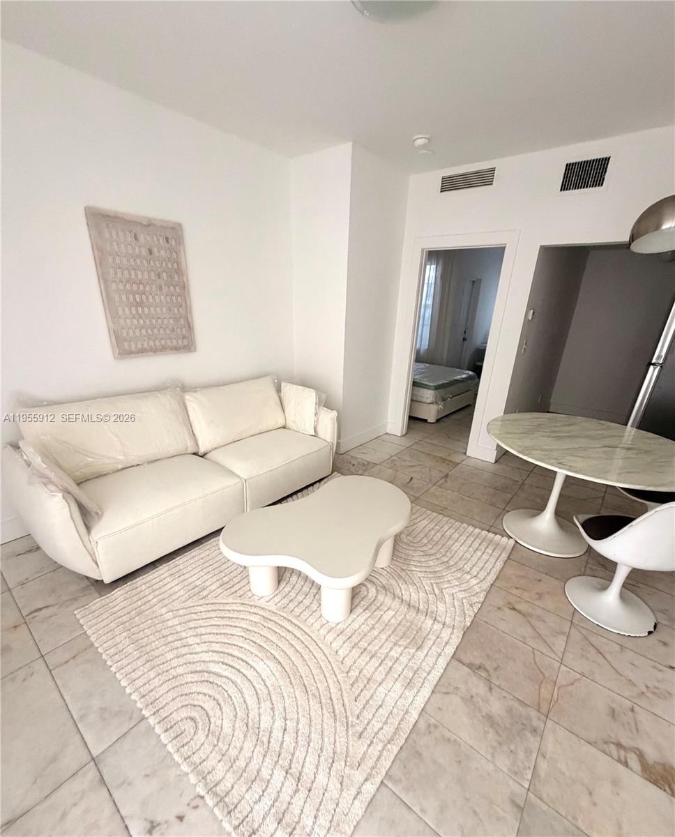 801 8th Street, Unit 202 Miami Beach, FL 33139 - Photo 3 of 9 a living room with a couch and a coffee table