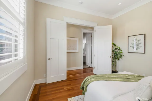 a bedroom with a bed and wooden floor