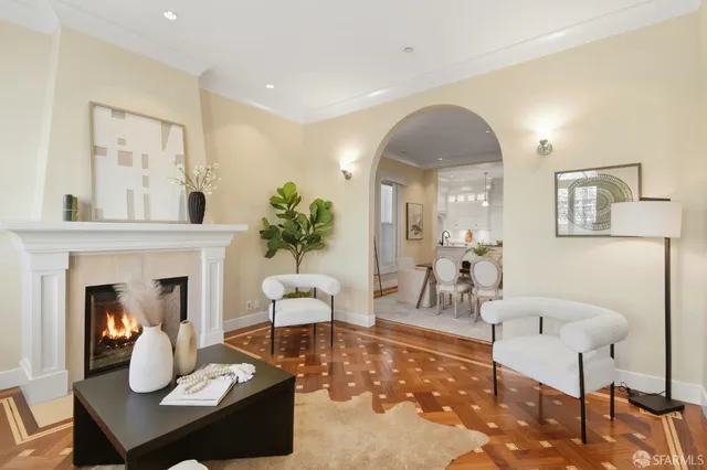 a living room with furniture a fireplace and a potted plant
