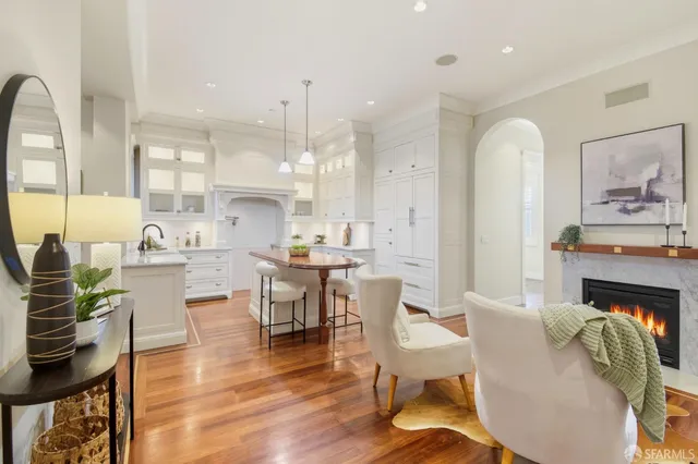a kitchen with white cabinets and wooden floor