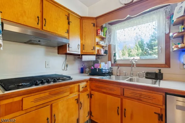 a kitchen with stainless steel appliances a sink stove and window