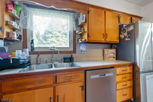 a kitchen with stainless steel appliances granite countertop a sink window and cabinets