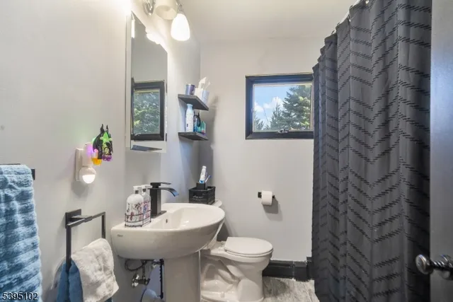 a bathroom with a sink toilet and a mirror