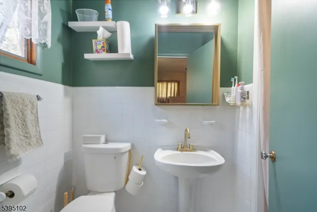 a bathroom with a toilet sink and mirror