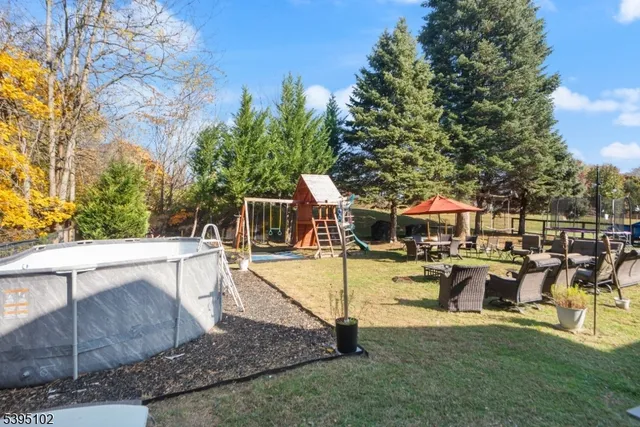 a view of a patio with table and chairs potted plants and large tree