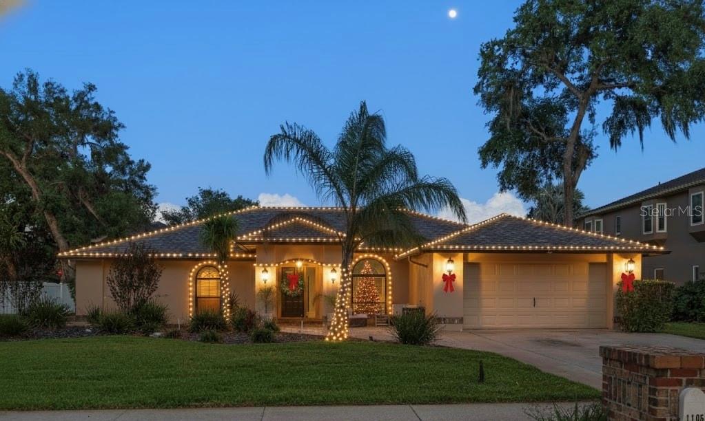 a front view of a house with a yard and potted plants