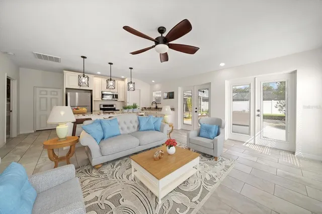 a living room with furniture and a view of kitchen
