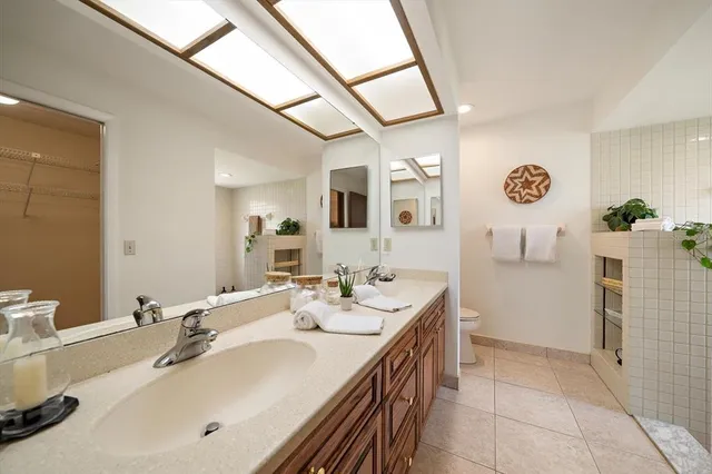 a spacious bathroom with a sink a mirror and a shower