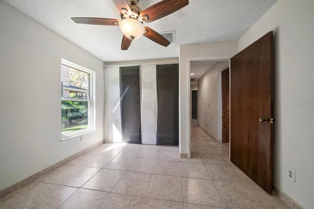 an empty room with a window and a fan