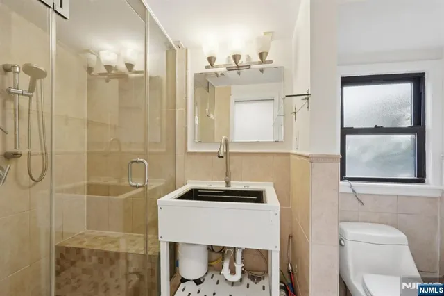 a bathroom with a shower a toilet and a sink