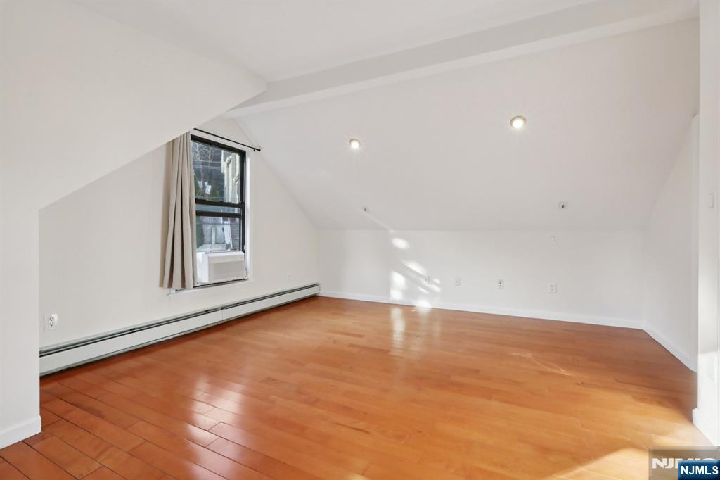 32 Hudson Terrace, Unit 2 Edgewater, NJ 07020 - Photo 34 of 42 a view of an empty room with wooden floor and a window
