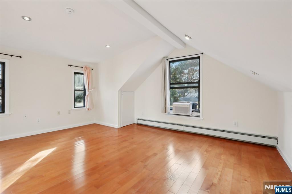 32 Hudson Terrace, Unit 2 Edgewater, NJ 07020 - Photo 35 of 42 an empty room with wooden floor and windows