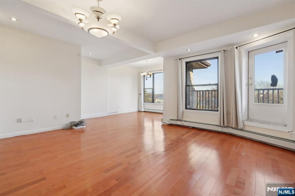 32 Hudson Terrace, Unit 2 Edgewater, NJ 07020 - Photo 5 of 42 an empty room with wooden floor chandelier fan and windows