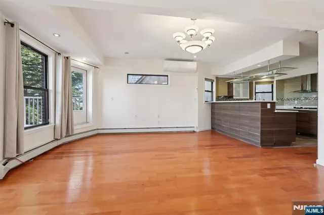 a view of an empty room with window and cabinet