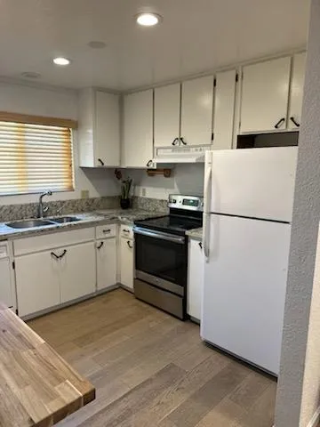a kitchen with a stove a refrigerator and a sink