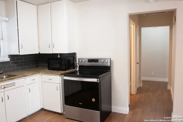 a kitchen with cabinets and a stove