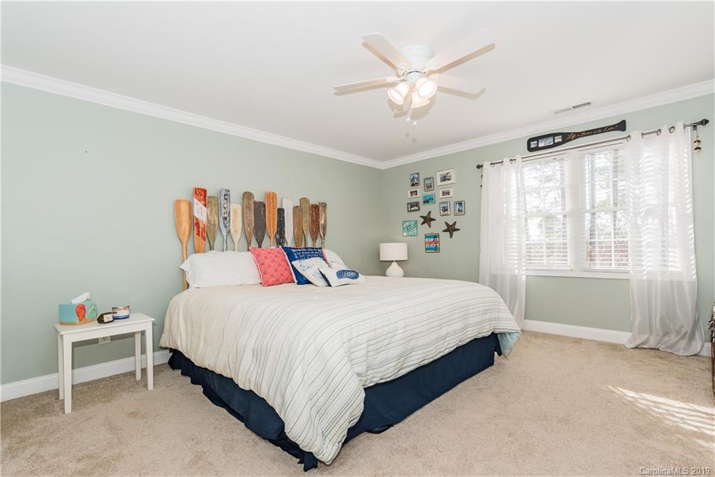 11161 Watertrace Drive Tega Cay, SC 29708 - Photo 14 of 24 a bedroom with a large bed and a chandelier